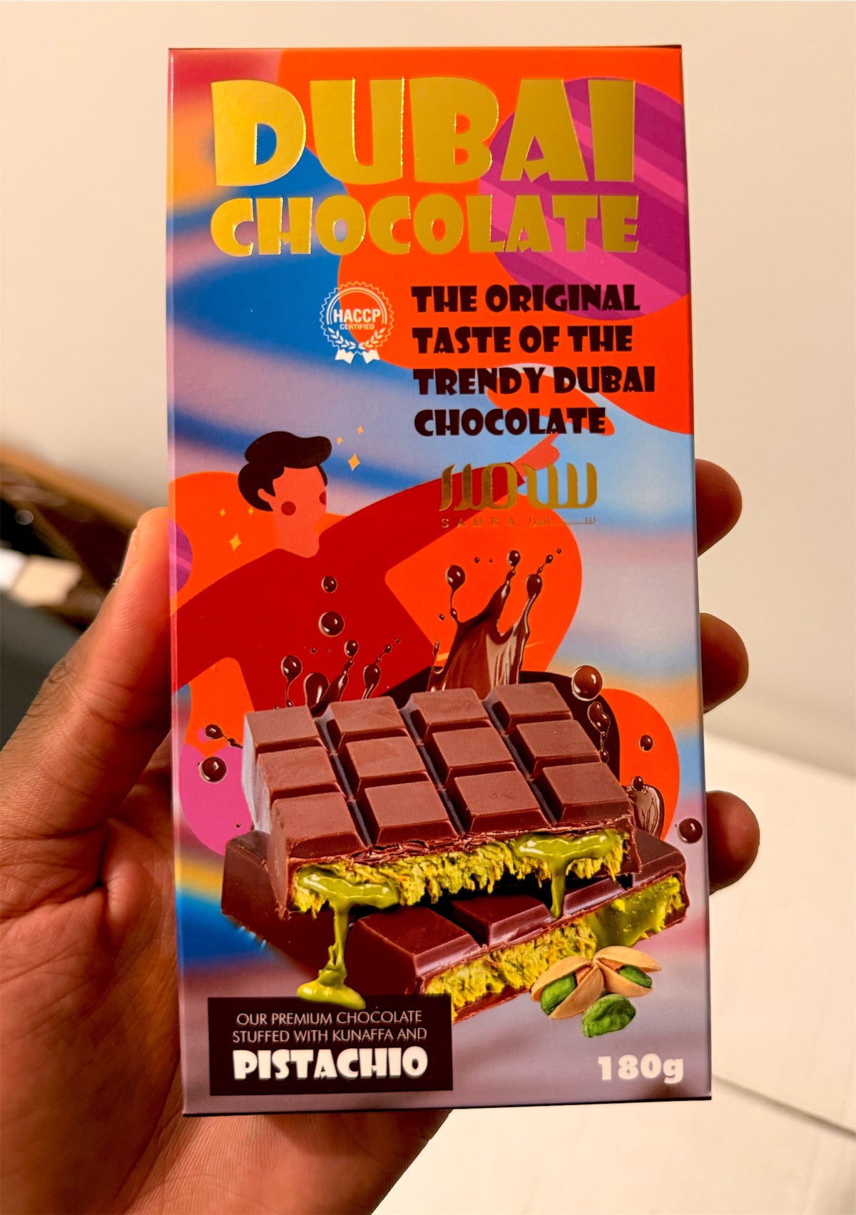 La tablette Dubai Chocolate 180 g tenue en main pour voir sa taille